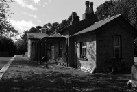 The single storey stone built station building at Cappagh, with the nameboard visible. Note the veranda on the platform, with cast iron supports similar to that found at nearby Cappoquin.