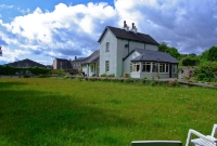The main station building, a two storey structure dating from 1878, is located on the former up platform. This view is looking towards Mallow. A mobile home business now occupies the former trackbed at the west of the station.
