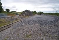 A view from the signal cabin at Castlebar, looking east towards Dublin, showing the trackless goods yard and disused goods shed. A single siding was retained here until 1993 for the loading of ballast trains, the points been operated by a ground lever frame.