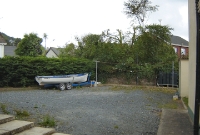 The stone wall visible beside the boat marks the boundary of where the tracks were sited at the Castleblayney Station, passing from left and right in this photo, taken roughly from the platform site.