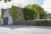 Another view of the concrete bridge abutment located at the north end of Castlecomer town. The abutments are located on the Kilkenny side of the road. Just visible through the trees is another former abutment, which belonged to a bridge carrying the railway across a tributary of the River Dinin.