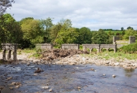 A river side view of the old concrete piers which once carried the railway bridge spanning the River Dinin.