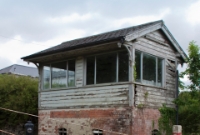 The typical Midland Great Western Railway style signal cabin at Castletown Station, located on the Mullingar side of the level crossing, which still retains its large crossing gates. The signal cabin is retained as a gatebox, but has been disused for many years now. The structure is also evidently missing its name board also.