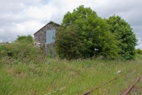 The partially visible stone built goods shed at Castletown. This was one of two sheds located at the station, this one being at the Athlone end on the &#39;Up side. It last handled goods traffic in 1963.