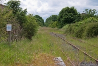 A similar view taken in June 2012, looking west towards Moate and ultimately Athlone, from the end of the former &#39;Down&#39; platform. The disused goods shed and loading bank are now totally overgrown, while CIE sign remains in situ on the left.