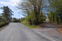 On the right is the original approach to the road overbridge once located at Clonakilty Jct. The road now forms part of driveway leading to a private house. After the bridge was demolished the road was realigned to its present formation to join the N71 at the former station site, visible in the distance.