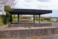 A view looking north along the line towards Clonakilty Jct. The signal cabin was once sited to the left. In the distance can be seen the derelict locomotive shed. A now disused storage area and canopy has been built on the former trackbed.