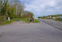 A view looking north towards Clonakilty Jct from the former County Home level crossing. The trackbed is to the left of the stone wall, while on the right is the N71 road which leads into the town.