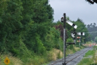 The rear of Clonmel&#39;s down home semaphore signal, with its additional bracket for the loop, as well as another ground disc. The level crossings in the distance are Cashel Road (R688) and Heywood.
