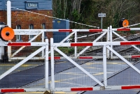 Close up shot of Clonsilla level crossing gates, showing the large oil lamp discs. The crossing is designated XG010, as displayed on the sign in the background. These discs have since been removed.