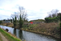 A view from the Grand Canal of Clonsilla Junction, with a 22000 Class railcar taking the sharp curve towards Sligo. Visible to the right beside the Navan line is a former locomotive shed.