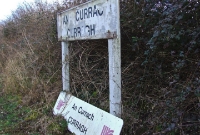 New and old name boards on the disused up platform at the Curragh, the grounded sign being of Irish Rail&#39;s 1990s vintage.