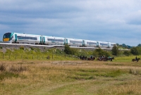 An &#39;up&#39; train formed of a 6-car 22000 Class railcar passes the Curragh plains west of the station heading for Dublin.