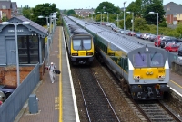 A view from the footbridge sees two trains passing the ex Great Northern signal cabin at Donabate. De Dietrich &#39;Enterprise&#39; driving van trailer No.9001 leads the 12:30 Belfast to Dublin service through the station, while a northbound commuter train departs for Drogheda.