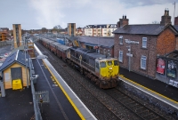 Viewed from the road overbridge at Donabate Station, 082 speeds through with its loaded Tara Mines train. The two storey building at this end of the station is now used as offices.