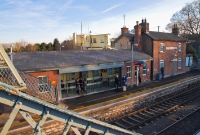 A late afternoon view of the brick built station buildings at Donabate, showing the recently refurbished booking office. The two storey structure carries a large wooden name board mounted onto the building.