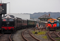 A39 in its restored 1960s black livery approaches Downpatrick Station with a vintage rake of ex CIE and Great Southern &#38; Western Railway coaching stock. The chain hanging above A39 is from water the tower, used by the Downpatrick steam locomotives.