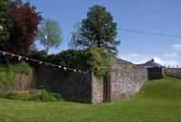 This is the site of the locomotive shed at the east end of Drimoleague Station. Today only its stone built retaining wall and part of the brick doorway remains. The shed had fallen out of use by the 1950s.