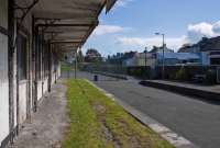 A view looking along the up platform towards Cork at Drimoleague Station. A tennis court now occupies the eastern end of the station site. On the right is the well maintained down platform.