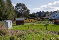 A view looking east towards Cork from the site of the road overbridge at Drimoleague Station. The railway line originally ran through a cutting here, which has been filled in since closure and now utilised as back gardens from the adjacent houses on the main street of the village.