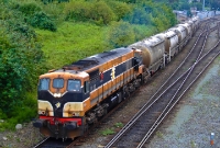 Seen at the same location is No.084 in the older orange &#38; black livery, hauling a loaded cement train from Platin to Dublin formed of the bogey bulk wagons. The cement traffic from Platin has since ceased.