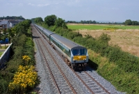 Propelled in the rear by 201 Class No.223, the 12:30 from Belfast gathers speed as it heads away from Drogheda with the Dublin bound Enterprise service. On the horizon in the right background is the former Boyne Road cement factory.