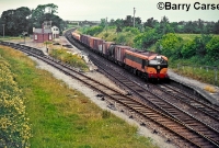 A southbound mixed freight is seen on the main line heading through the forlorn looking Dromin Jct Station, hauled by 001 Class No.005. The signal cabin at Dromin would only be open when an Ardee branch goods train was due. To the right on the up platform can be seen the fenced access path which lead up the adjacent road overbridge. ©Barry Carse