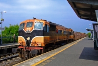 Sister loco No.076, still in its orange &#38; black livery, is seen on a much brighter day bringing up the empty timber wagons from Waterford to North Wall yard, where the loco would run around the train and continue towards Sligo.