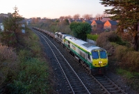 201 Class loco No.217 in &#39;Intercity&#39; livery hauls a failed 071 Class loco No.072 on a train of scrap rails from the Sligo line past Claude Rd, bound for the North Wall yard.