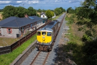 Loco No.086 is captured again, heading past the former station at Duleek with the rake of empty ore wagons from Dublin Port to Tara Mines. Visible in the background beyond the station building is the GNR station masters house.