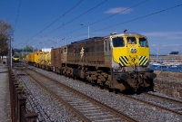 Seen having past a Howth bound DART just north of Dun Laoghaire is 071 Class loco No.071, heading the annual Irish Rail weed spraying train from Dublin to Rosslare. The loco is seen adorned with its yellow and black striped warning placards. To the right is the harbour at Dun Laoghaire.