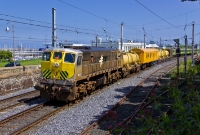 No.071 is seen returning from Bray as it sprays the Up line back towards Dublin City. The train is seen at the north end Dun Laoghaire having passed a southbound DART which can be seen arriving at the station. No.071 was built by General Motors in 1976.