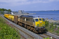 The weed spraying train is seen again with No.071 in charge, this time approaching the curve near Seapoint Station north of Dun Laoghaire. The train is travelling to Bray before spraying the &#39;Up&#39; line back into Dublin City. In the background can be seen a 19th century Martello tower, now used as the HQ of the Genealogical Society of Ireland.