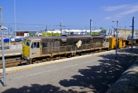 Another 071 Class locomotive, this time No.085, is seen taking an empty ballast train through Dun Laoghaire&#39;s up platform. The vehicle travelling behind the loco is the obligatory guards van, which is fitted with a ballast plough.