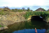 This is actually the River Tolka itself, which the line crosses on yet another low culvert style bridge. This bridge, as with the others, have since been rebuilt in concrete following the line&#39;s restoration.