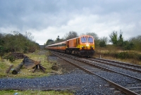 201 Class locomotive No.212 passes the overgrown goods loading bank at the south end of Dundrum Station as it heads a northbound express to Dublin formed of Mk3 coaching stock.