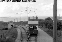 Great Northern Railway&#39;s Howth Tram No.7 pauses at Dungriffan Road stop on a service from Howth to Sutton in 1957. To the left is a typical wooden GNR waiting shelter. ©Wilson Adams Collection