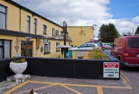 This is the hotel which was once located adjacent to the approach road leading to Dunmanway Station, which is just visible in the background behind some trees. Since closure of the line in March 1961, the hotel and its car park have been extended onto the former trackbed.