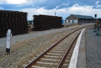 Wexford, looking south towards Rosslare, with the upgraded concrete sleepers and long welded rails and colour light signal. In the background is the large DWWR goods shed. The milepost visible on the left is measured from Harcourt St Station in Dublin City.