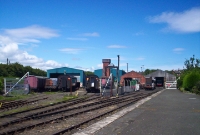 This is the RPSI&#39;s Whitehead base, located just north of the station. The platform in the foreground was originally an excursion platform, which had fellan out of use by the 1930s. The RPSI base consists of workshops, engine and carriage sheds, as well as a tall water tower.