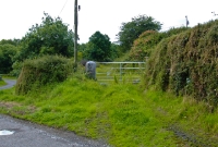 Willbrook Station, as viewed from the former level crossing, the short platform and waiting shelter were located beyond the gate. One of the former stone gate posts for the level crossing remains.