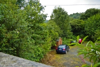 The first road overbridge on the closed 1952 branch line from Woodenrbridge to Shillelagh. The parapet of the stone bridge is in the foreground.